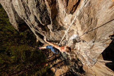 Climber Extreme üst sigorta ile bir ip üzerinde bir kaya tırmanıyor, yukarıdan üst görünümü