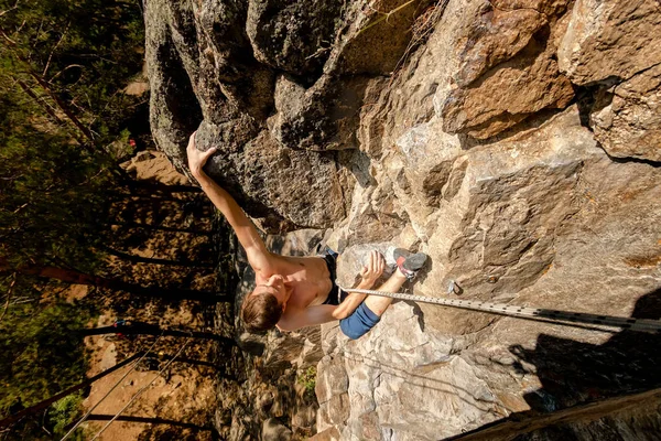 Climber Extreme climbs a rock on a rope with the top insurance, top view from above — Stock Photo, Image