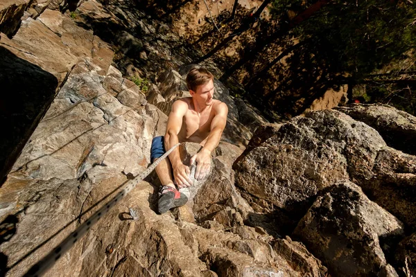 Extremkletterer besteigt einen Felsen an einem Seil mit der Top-Versicherung, Blick von oben — Stockfoto