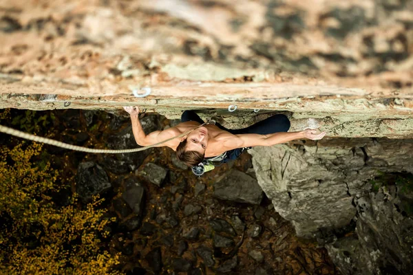 Bergsteiger klettert an einem Seil auf eine Klippe, Blick von oben — Stockfoto