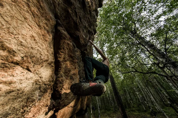 Rock klättraren klättrar bouldering på en klippa på skogen. Låg vinkel av stark bergsklättring man hängande gratis på Rock med sunflare — Stockfoto