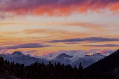 Kırmızı turuncu mavi bulutlar gradyan gün batımında Panorama siluet orman ve dağ üstleri