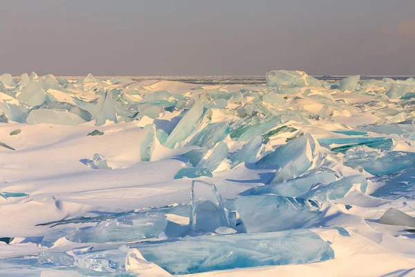 Transparente azul Toros Baikal gelo está brilhando através do pôr do sol crack — Fotografia de Stock