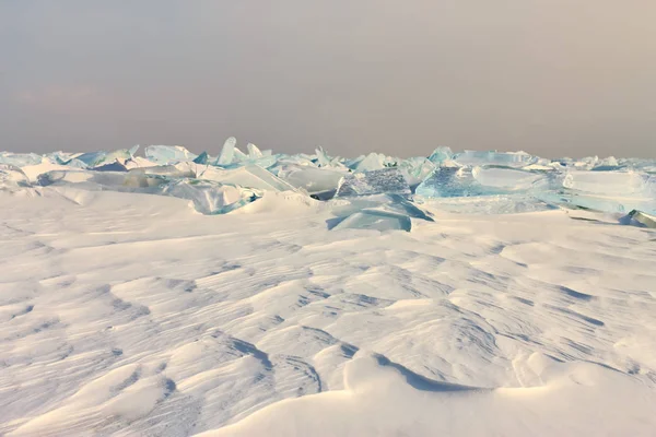 Transparente azul Toros Baikal gelo está brilhando através do pôr do sol crack — Fotografia de Stock