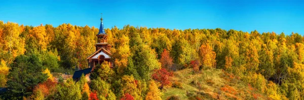 Tempio di legno sul lago Baikal tra gli alberi gialli della foresta autunnale. Panorama Russia Immagini Stock Royalty Free