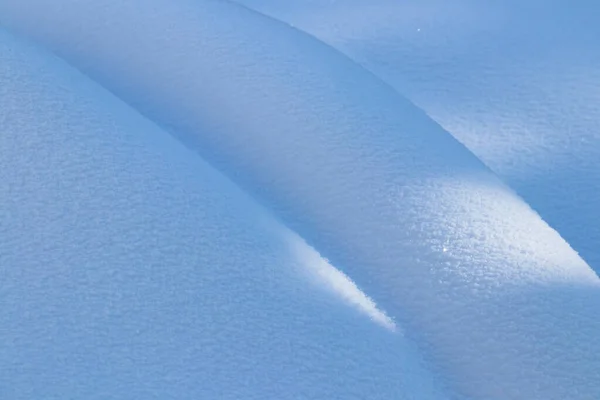 Όμορφη λεία γραμμές υφή του snowdrifts παιχνίδι του φωτός και της σκιάς του χειμερινού τοπίου στο παρασκήνιο — Φωτογραφία Αρχείου