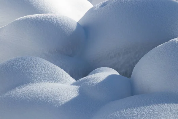 Bella trama linee lisce di cumuli di neve gioco di luce e ombra di un paesaggio invernale sullo sfondo — Foto Stock