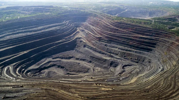 Aerial view of opencast mining quarry with lots of machinery at work. Mining-dressing quarry