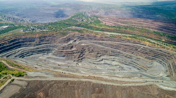 Bir sürü makinenin çalıştığı açık maden ocağının havadan görünüşü.
