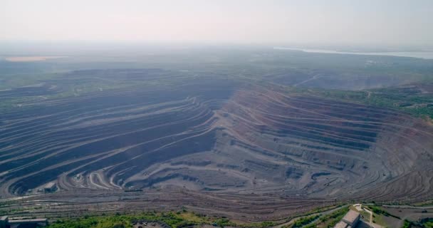 Aerial view of opencast mining quarry with lots of machinery at work. — Stock Video