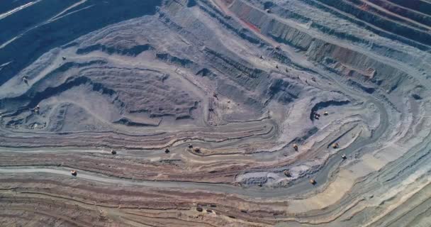 Aerial view of opencast mining quarry with lots of machinery at work. — Stock Video