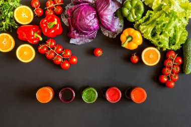 Renkli taze organik sebze ve siyah bir zemin üzerine ev yapımı farklı kadeh seti.