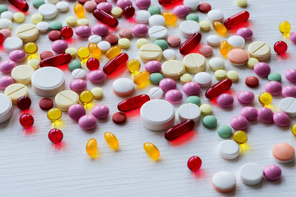 Many colorful medicines. Pills and capsules on white background.