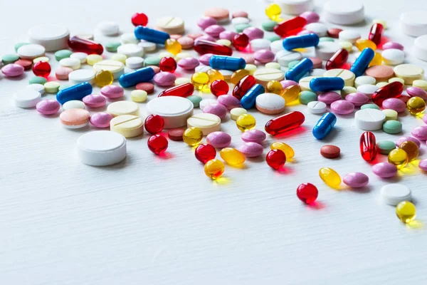 Πολλά πολύχρωμα φάρμακα. χάπια και κάψουλες σε άσπρο φόντο. — Φωτογραφία Αρχείου