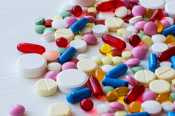 Many colorful medicines. Pills and capsules on white background.