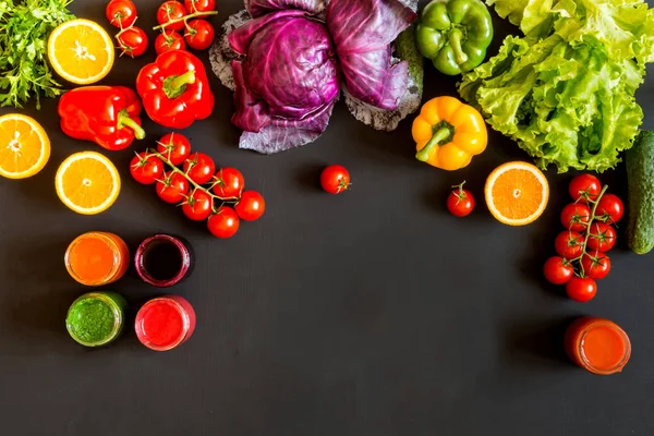 Vegetais orgânicos coloridos frescos e conjunto de bebidas diferentes caseiras em um fundo preto . — Fotografia de Stock