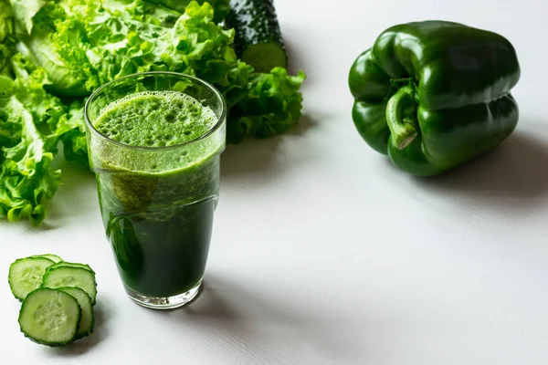 Bir bardak beyaz zemin üzerine yeşil sebze güler yüzlü. Kopya alanı.