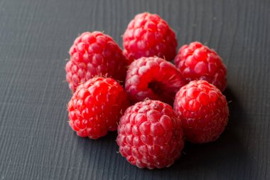 Taze ve lezzetli ahududu seyir üzerinde siyah bir ahşap tablo