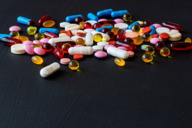 Farklı renkli ilaçlar. Hap ve kapsül siyah arka plan üzerine. Kopya alanı.