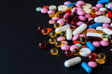 Farklı renkli ilaçlar. Hap ve kapsül siyah arka plan üzerine. Kopya alanı.