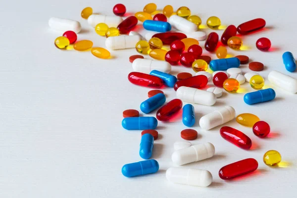 Διάφορα πολύχρωμα φάρμακα. Χάπια και κάψουλες σε άσπρο φόντο. Χώρο αντίγραφο. — Φωτογραφία Αρχείου