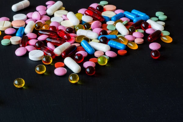 Διάφορα πολύχρωμα φάρμακα. Χάπια και κάψουλες σε μαύρο φόντο. Χώρο αντίγραφο. — Φωτογραφία Αρχείου