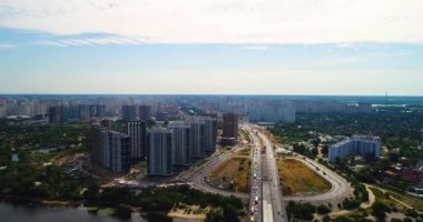 Güney Köprüsü. Birçok bina hava görünümünü. Dinyeper Nehri. Yaz. Güneş. Bir gün. Yeşil ağaçlar. Yüksek binalar. Yol. Arabalar. Altyapı. Gökyüzü. Bulutlar. Kiev.