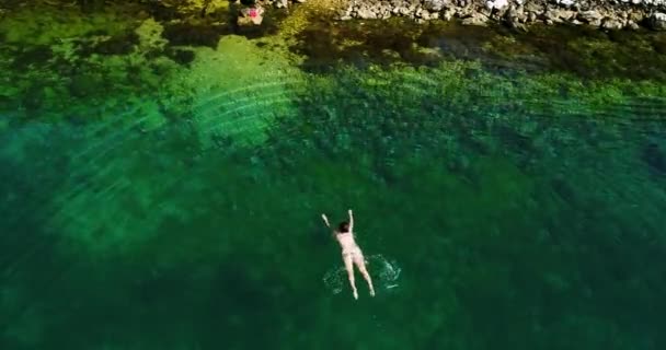 Νεαρή γυναίκα κολύμβησης στην όμορφη γαλάζια θάλασσα. — Αρχείο Βίντεο