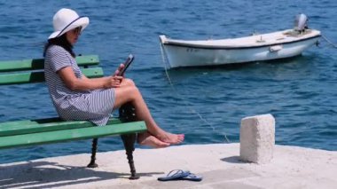 Güzel genç kız tablet ve gülümsüyor sosyal ağ resimlerde bakar