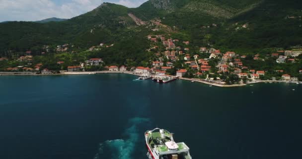 Vista aérea hermosa desde arriba a la bahía de Kotor y ferry regular de pasajeros de Lepetane a Kamenari por una tarde soleada — Vídeos de Stock