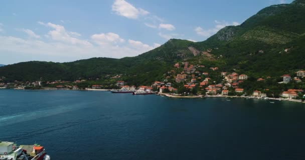 Vista aérea hermosa desde arriba a la bahía de Kotor y ferry regular de pasajeros de Lepetane a Kamenari por una tarde soleada — Vídeo de stock