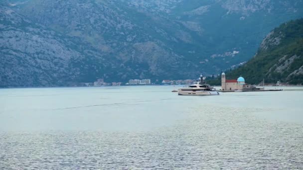 Kilátás nyílik a Kotori-öbölben, közel város Perast, Montenegró sziklák templom Miasszonyunk — Stock videók