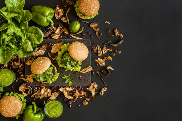 Vegan hamburgers met bieten kotelet en groene smoothies op zwarte achtergrond. Gezond veganistisch eten. Detox dieet. — Stockfoto