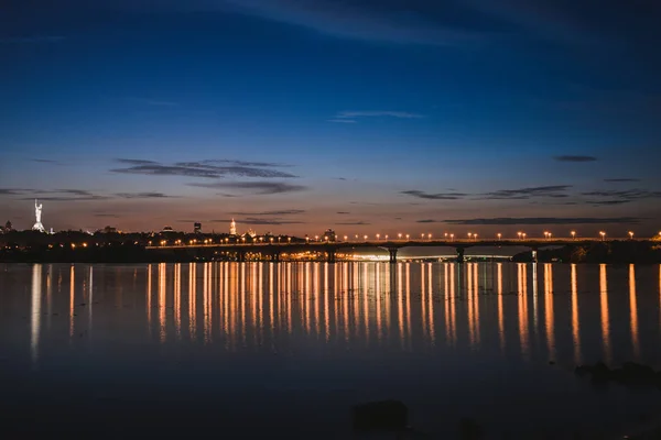 Панорама города Киева ночью. Киевский левый берег с Патонским мостом через Днепр . — стоковое фото