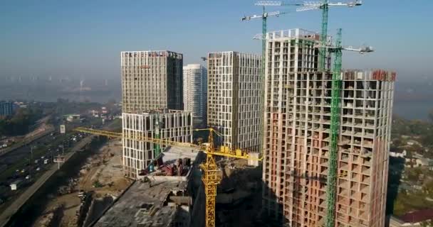 Vue aérienne du paysage de la ville avec des bâtiments en construction et des grues industrielles. Travaux de construction . — Video