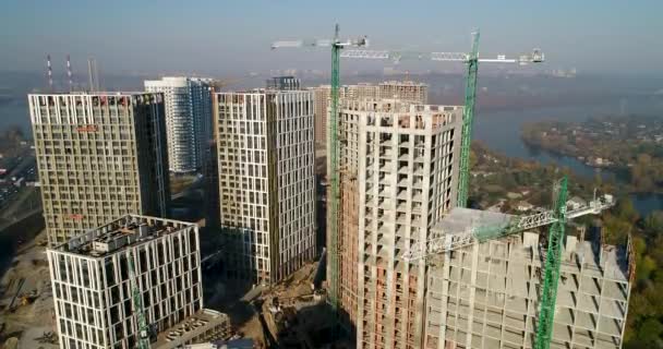 Vista aérea del paisaje en la ciudad con edificios en construcción y grúas industriales. Lugar de construcción . — Vídeo de stock