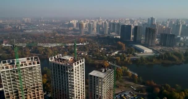 Luftaufnahme einer Landschaft in der Stadt mit im Bau befindlichen Gebäuden und Industriekränen. Baustelle. — Stockvideo