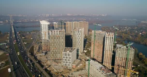 Vista aérea del paisaje en la ciudad con edificios en construcción y grúas industriales. Lugar de construcción . — Vídeo de stock