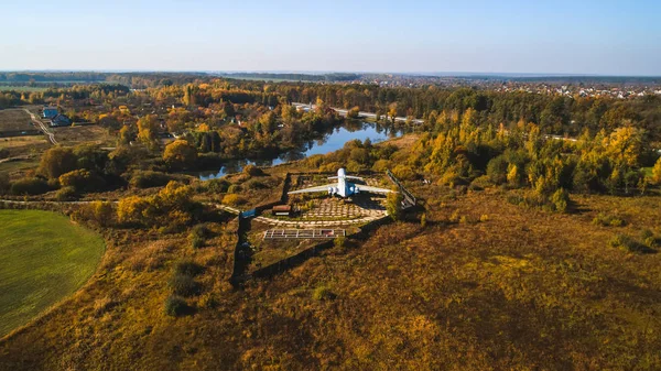 Vista aérea del avión en el bosque otoñal cerca del lago y hermoso paisaje. Hermoso paisaje de otoño con un avión . — Foto de Stock