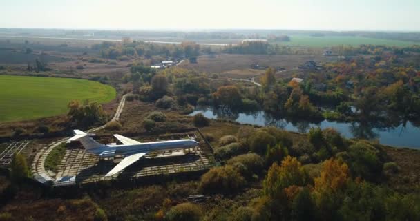 Widok z lotu ptaka płaszczyzny w lesie jesienią, w pobliżu jeziora i piękny krajobraz. Piękny krajobraz jesień z samolotu. — Wideo stockowe