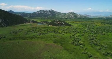 Güzel güneşli bir hava görünümünü Gölü İşkodra mountain ve adanın Manastırı ile manzara. Karadağ. Bitkilerle büyümüş Gölü bölgesi İşkodra.