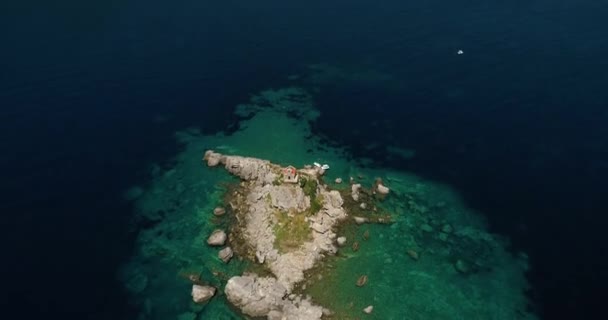 Flygfoto över en vacker ö med kyrkan i Adriatiska havet. Allmän översikt över den staden Petrovac. — Stockvideo