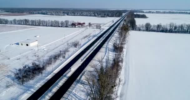 Вид с воздуха на снежную дорогу зимой — стоковое видео