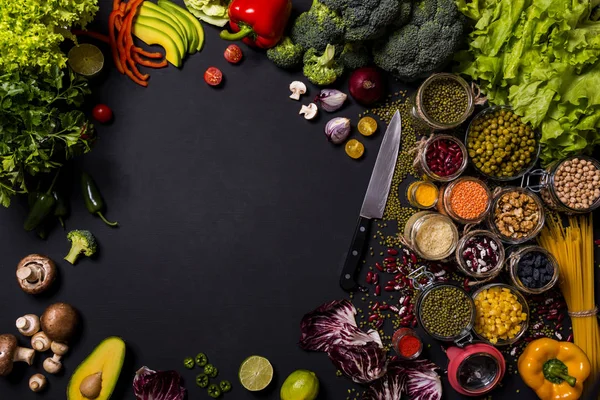 Tendência conjunto de vegetais frescos e frutas em fundo preto. Diferentes alimentos vegan frescos coloridos. Deitado. Espaço para texto . — Fotografia de Stock