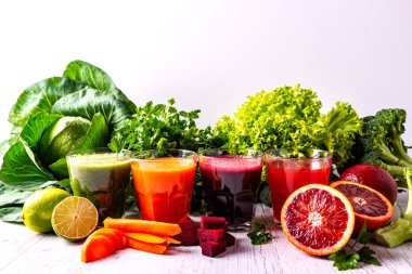 Meyve ve sebze Beyaz ahşap zemin üzerinde farklı sağlıklı vegan içecekler.