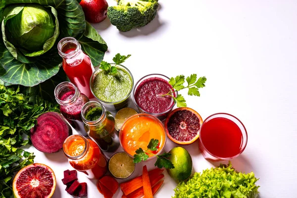 Diferentes bebidas veganas saludables con frutas y verduras en el fondo de madera blanca. Puesta plana . — Foto de Stock