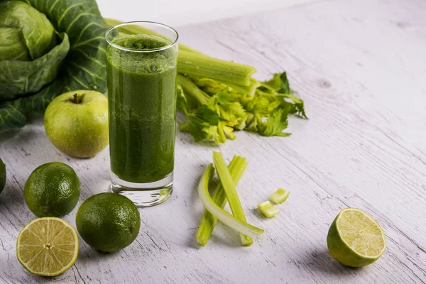 Zelená zeleninová detoxikační koktejl ve skle na dřevěné bílé pozadí pohled shora — Stock fotografie