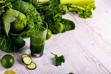 Yeşil cam, ahşap beyaz arka plan ile salatalık güler yüzlü Detoks.