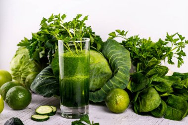 Yeşil cam, ahşap beyaz arka plan ile salatalık güler yüzlü Detoks.