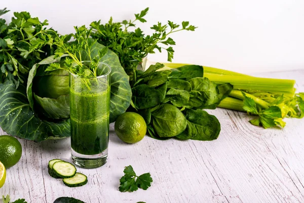 Detox okurka smoothie v zeleni v blízkosti skla na dřevěné bílé pozadí. — Stock fotografie